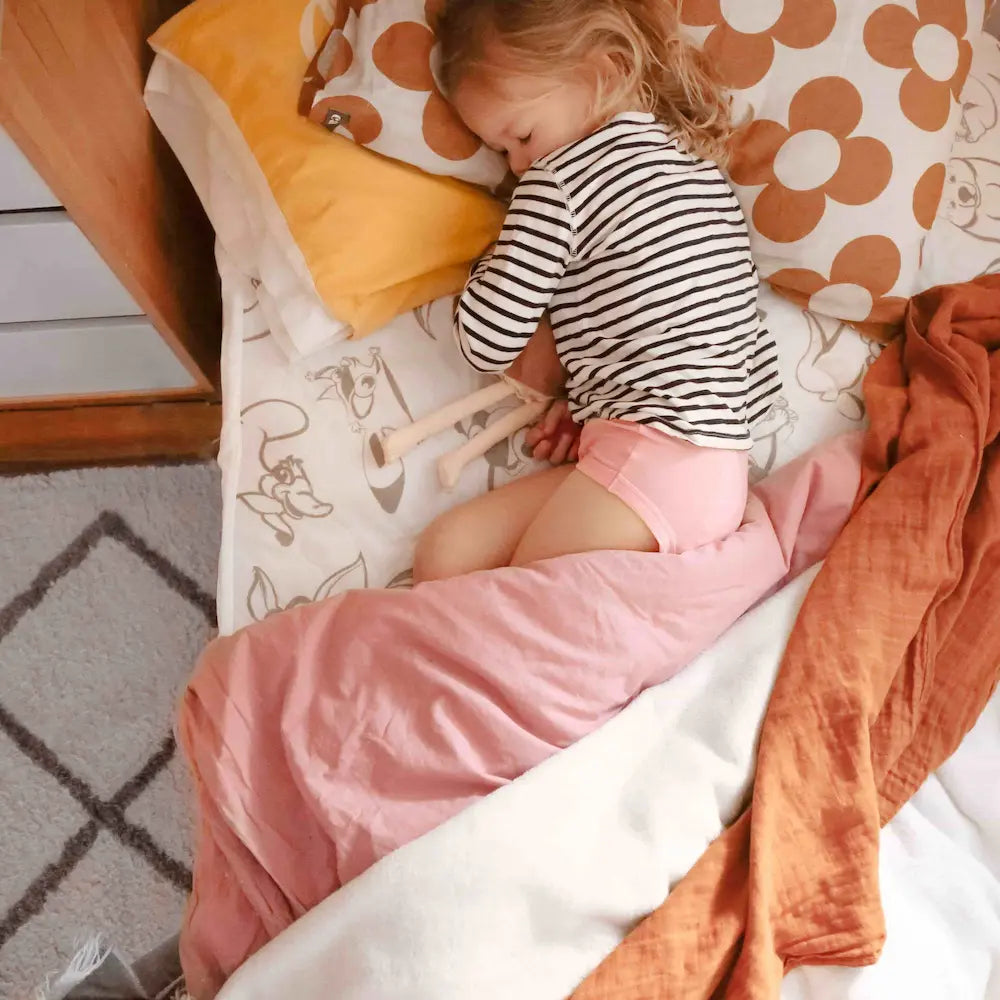 Conni Kids for bedwetting and children incontinence with child in bed wearing products 